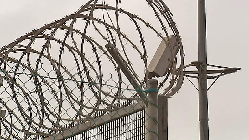 Prison razor wire and surveillance camera.