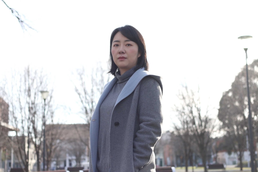 A Chinese woman standing in an empty park