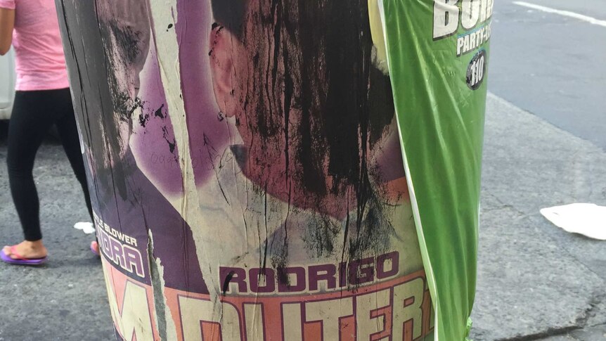 Rodrigo Duterte's face is scratched out on a campaign poster.