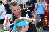 Up close ... Lleyton Hewitt signs an autograph during a promotional event in Brisbane