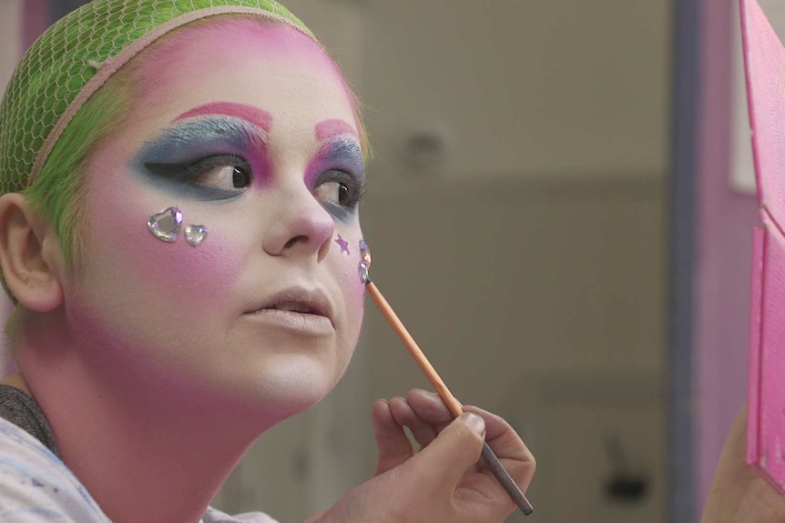 Drag performer Kat Daddi applying facial sequins