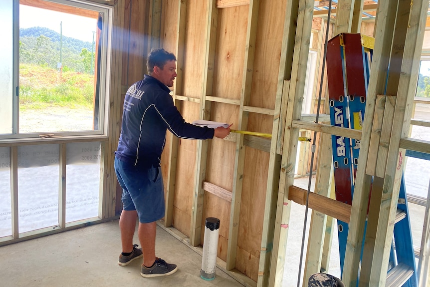 Builder Sonny-Jim Fulton does some measuring inside a house he is building.