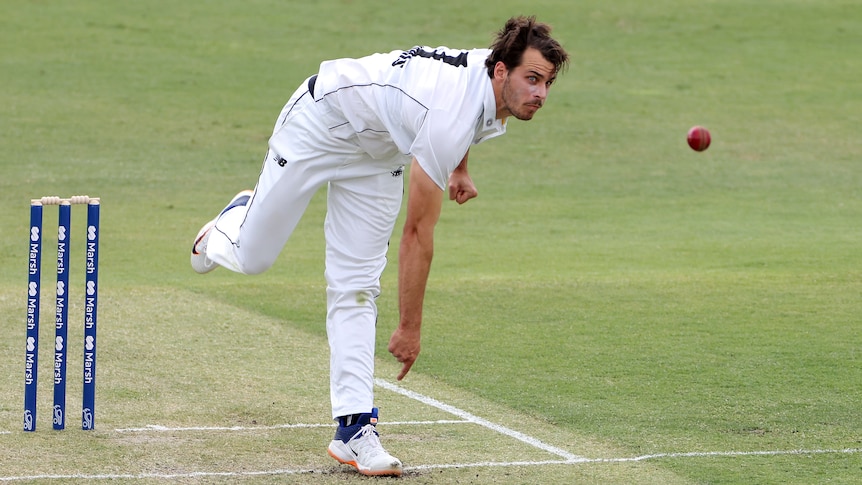 A Western Australian paceman follows through after delivering a ball during a Shield match.
