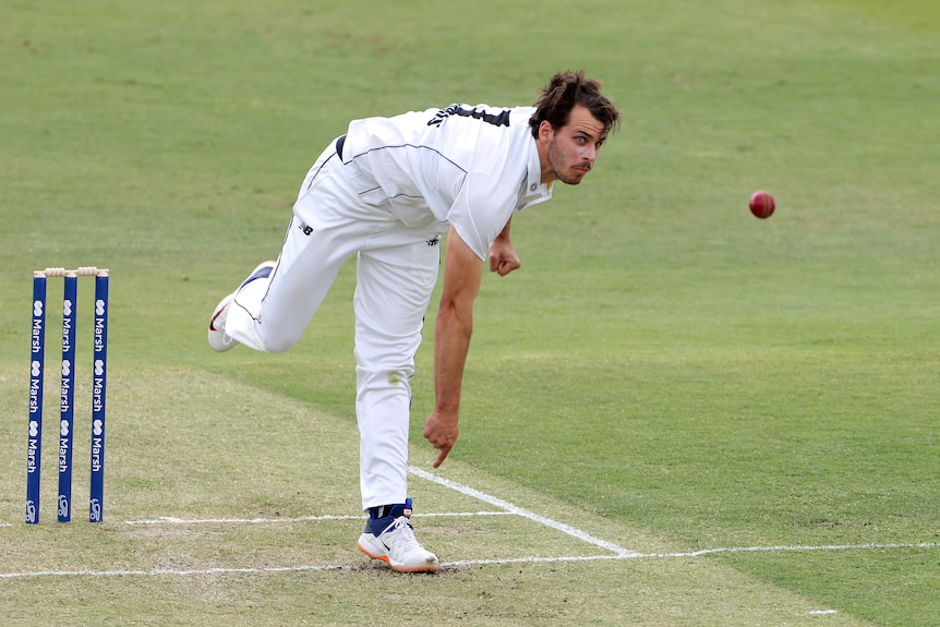 A Western Australian paceman follows through after delivering a ball during a Shield match.