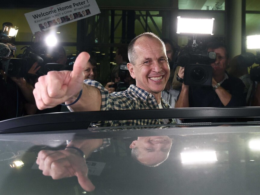 Peter Greste celebrates his arrival at Brisbane Airport.