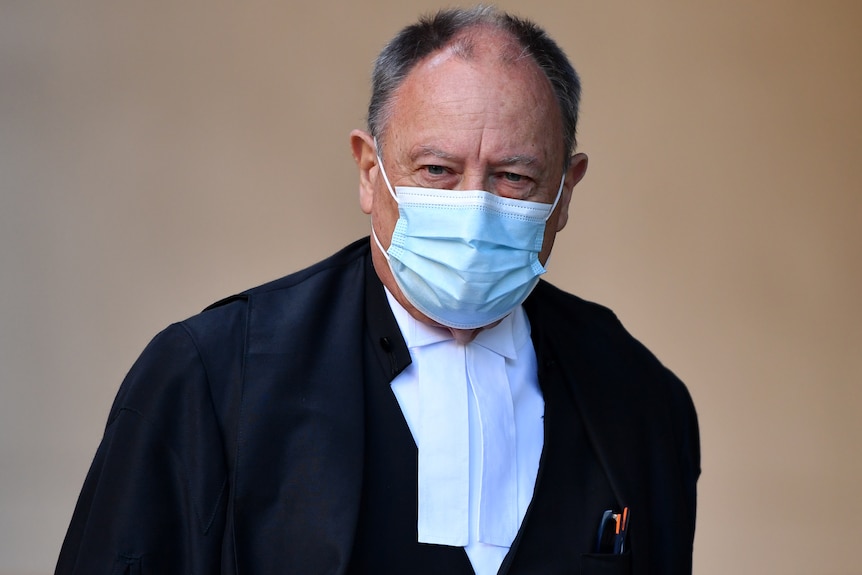 a man wearing a masks about to enter court