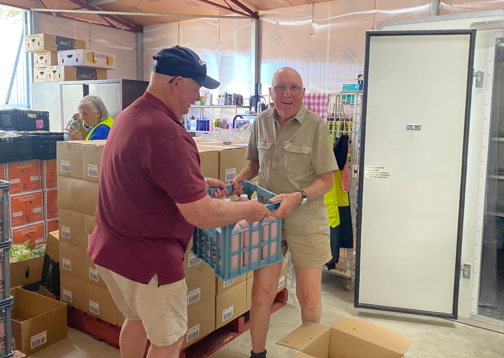 Uma tomada média de dois homens segurando uma caixa.