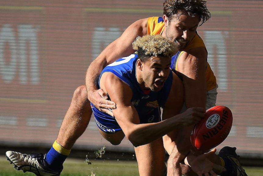 West Coast Eagles tagger Mark Hutchings tackles Western Bulldogs defender Jason Johannisen as he holds the ball.