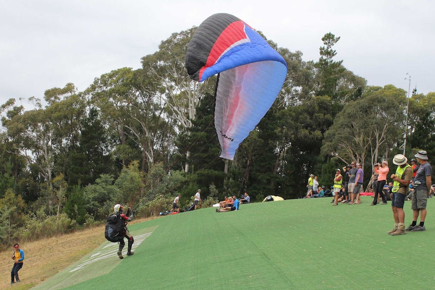 A man is about to take to the air after running down a steep hill.