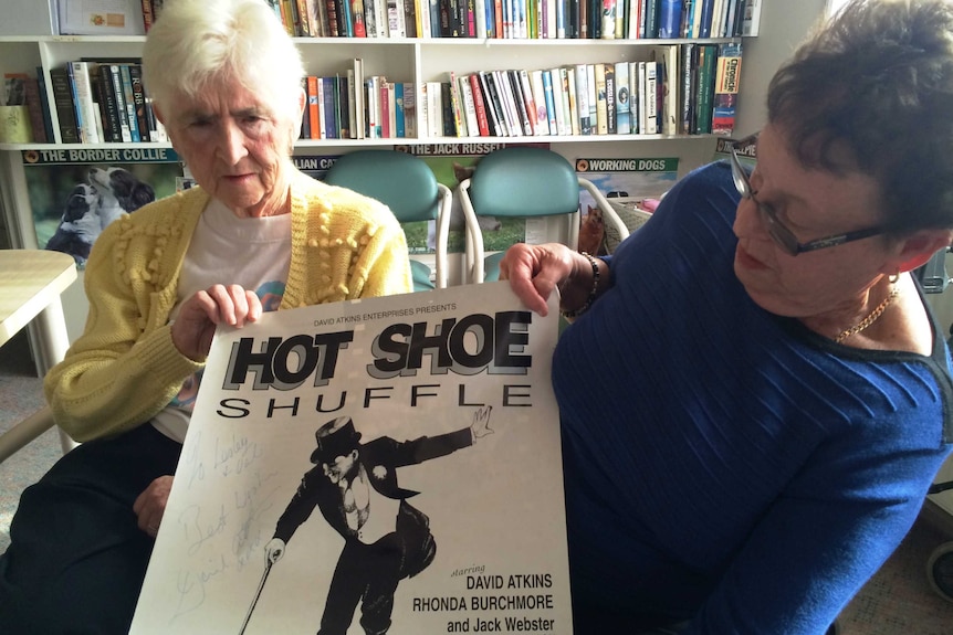 Val Lawson and Leslie Fitzpatrick hold up show poster