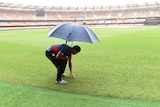 Bangladesh captain Mashrafe Mortaza checks the Gabba outfield as rain falls on February 20, 2015.