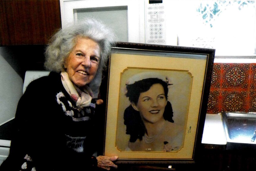 Mary Heather Lane holding a photograph of herself