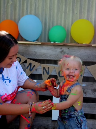 Mum and toddler play with paint.