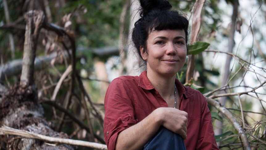 Ecologist Gabrielle Davidson sits on fallen tree in the Kutini-Payamu (Iron Range) National Park.