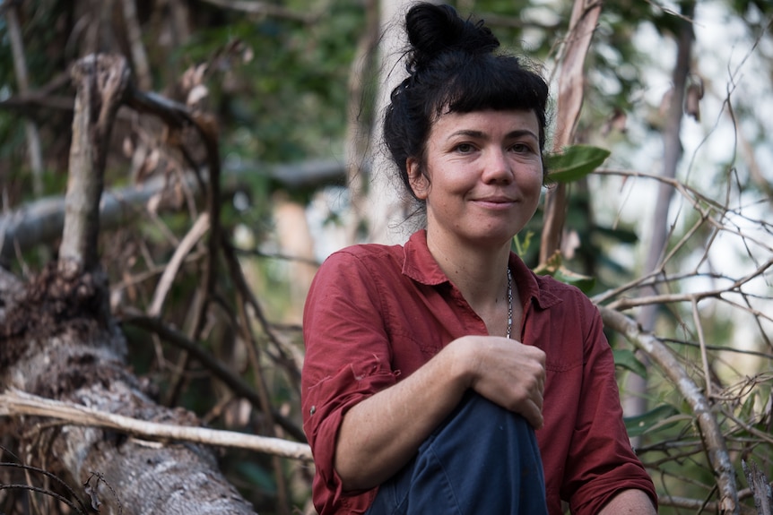 Ecologist Gabrielle Davidson sits on fallen tree in the Kutini-Payamu (Iron Range) National Park.