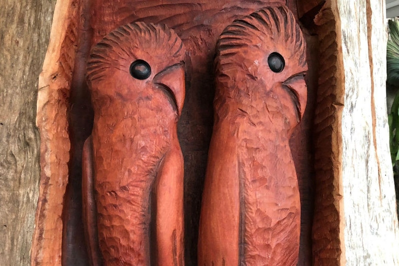A large wood carving of two birds