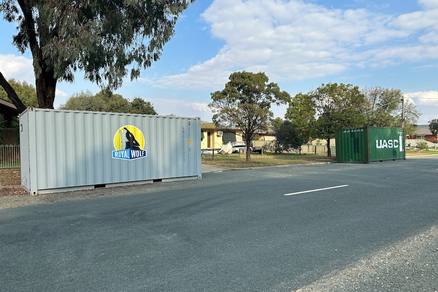 A shipping container sits in a street