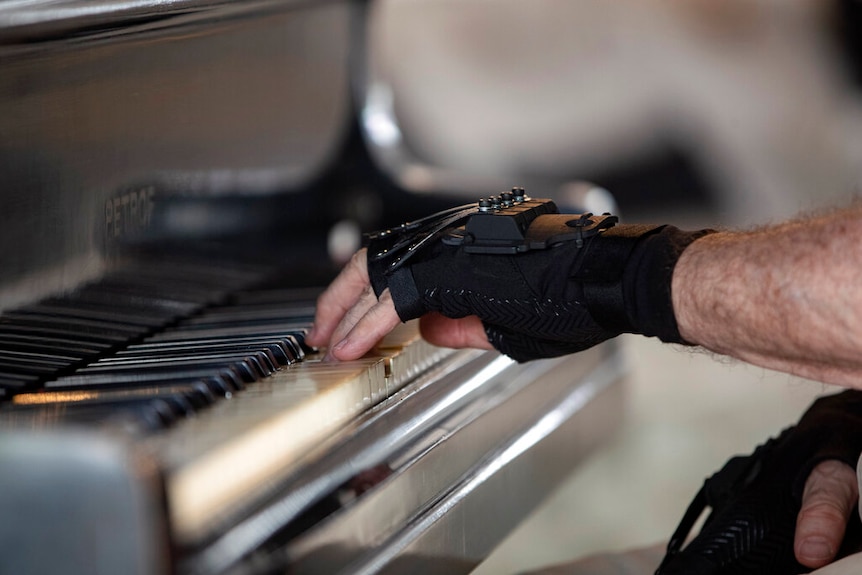 Martins playing piano with his bionic gloves.