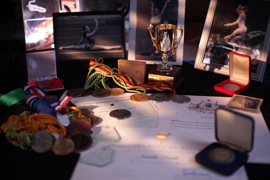 Medals, ribbons and certificates laid out on a table.