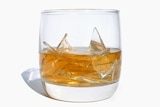 A whisky glass with broken glass in it.