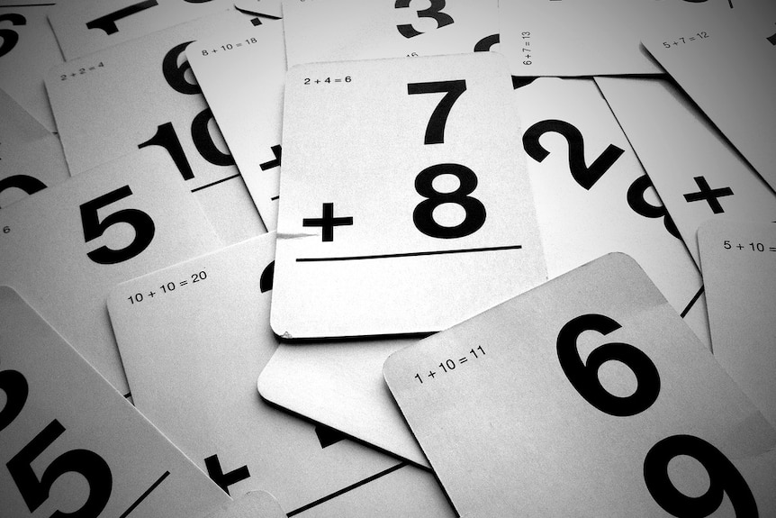 A deck of addition cards for primary school children lie on a table.