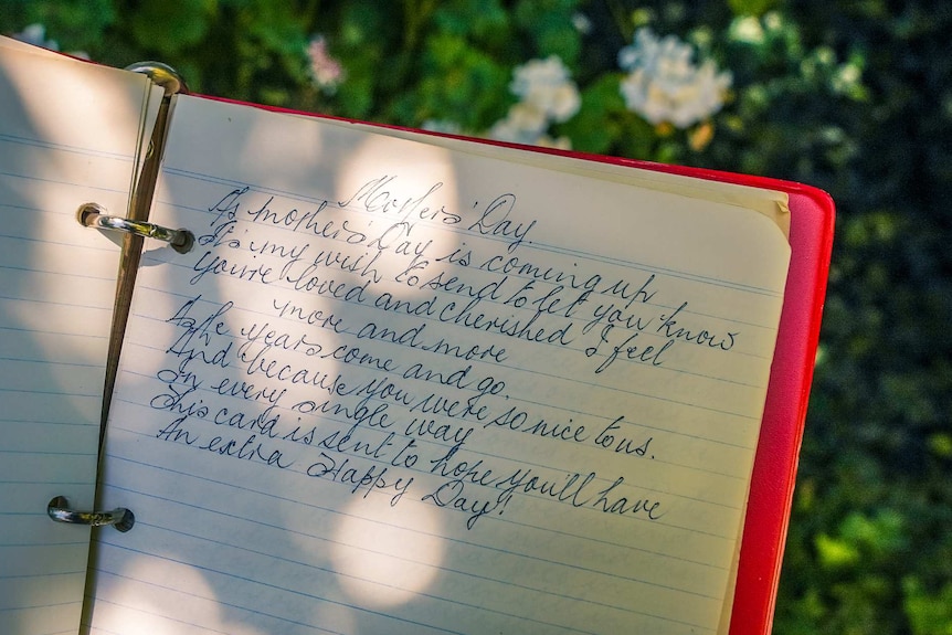 An open red notebook with a handwritten entry titled 'Mother's Day'.