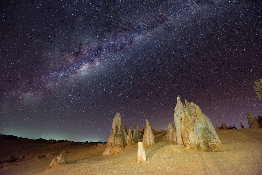 Rock formations with the sun behind them.