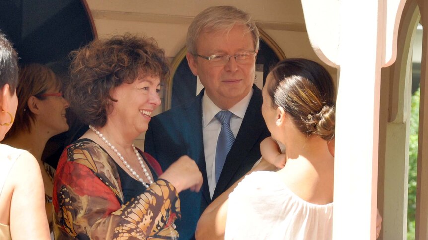 Kevin Rudd and his wife Therese Rein talk to a mother and baby