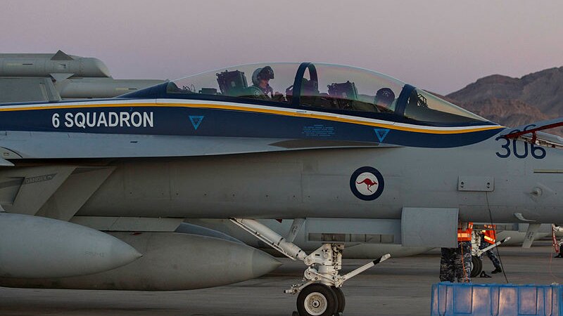 Two RAAF officers are seen in a plane as it lands on a tarmac