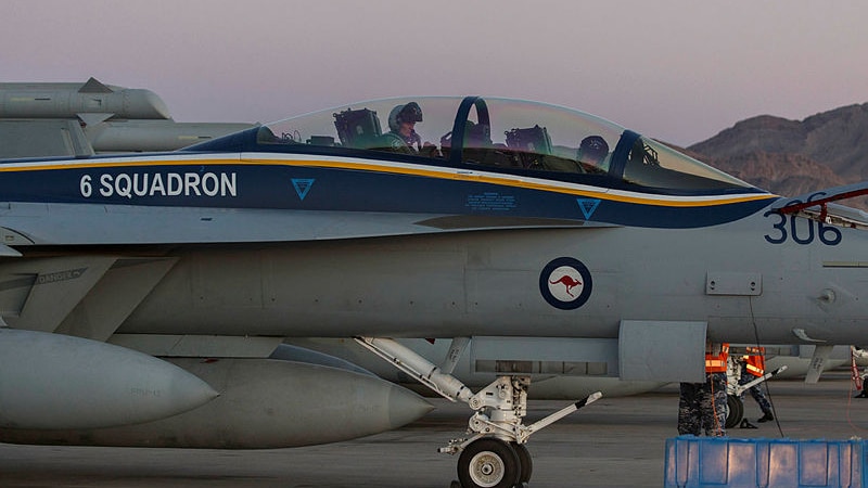 Two RAAF officers are seen in a plane as it lands on a tarmac