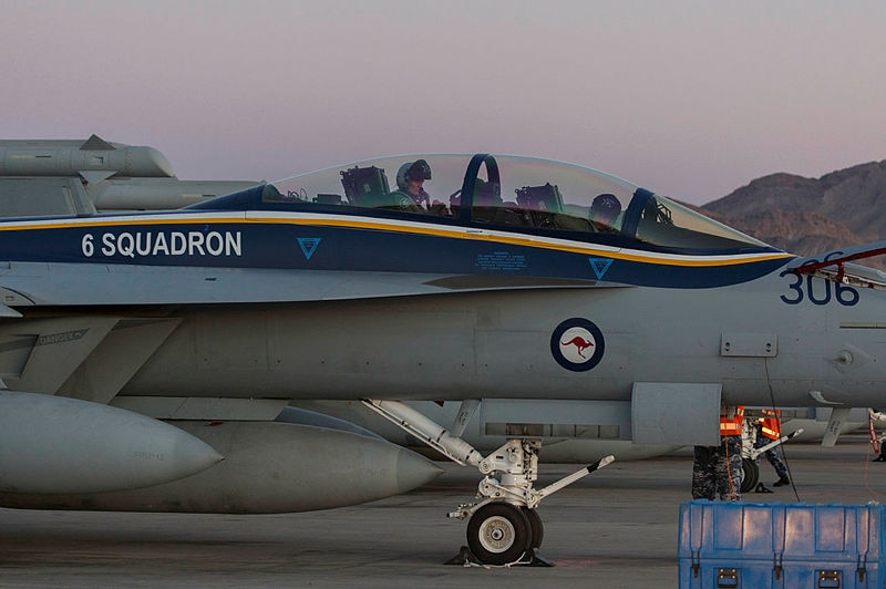 Two RAAF officers are seen in a plane as it lands on a tarmac