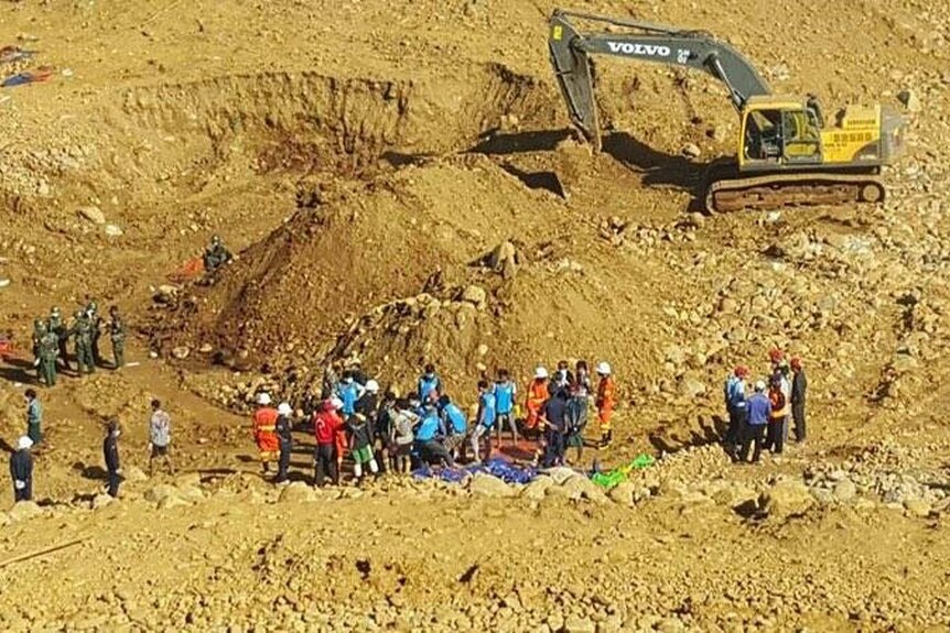 Rescue workers search for the bodies of miners killed in a landslide