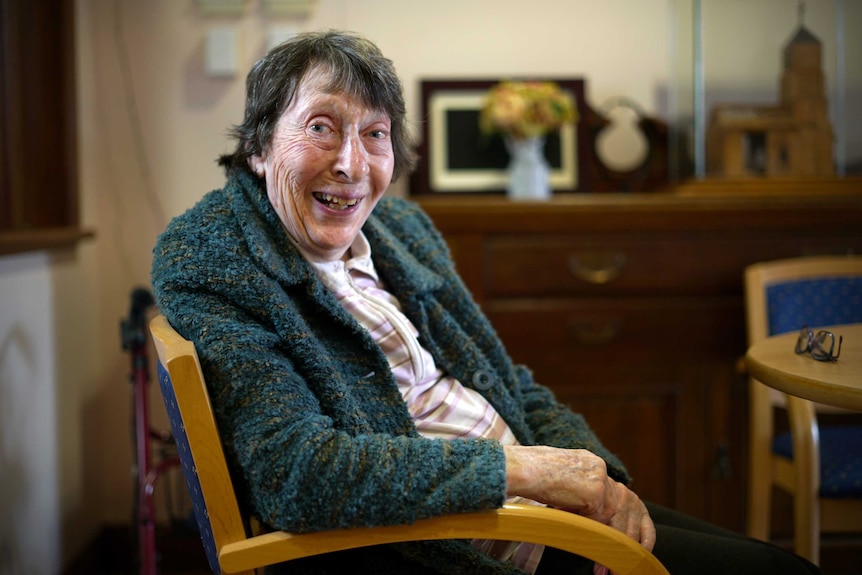 Shirley Laas smiles while sitting in a chair