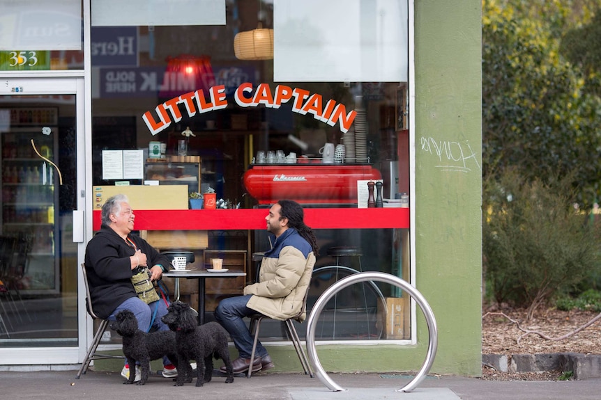 Maggie and Scott sit at a cafe.