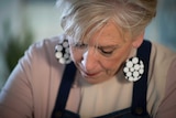 Maggie Beer looks down while cooking