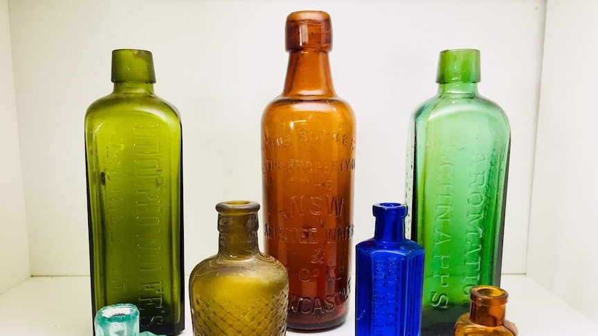 A collection of coloured bottles on a white table
