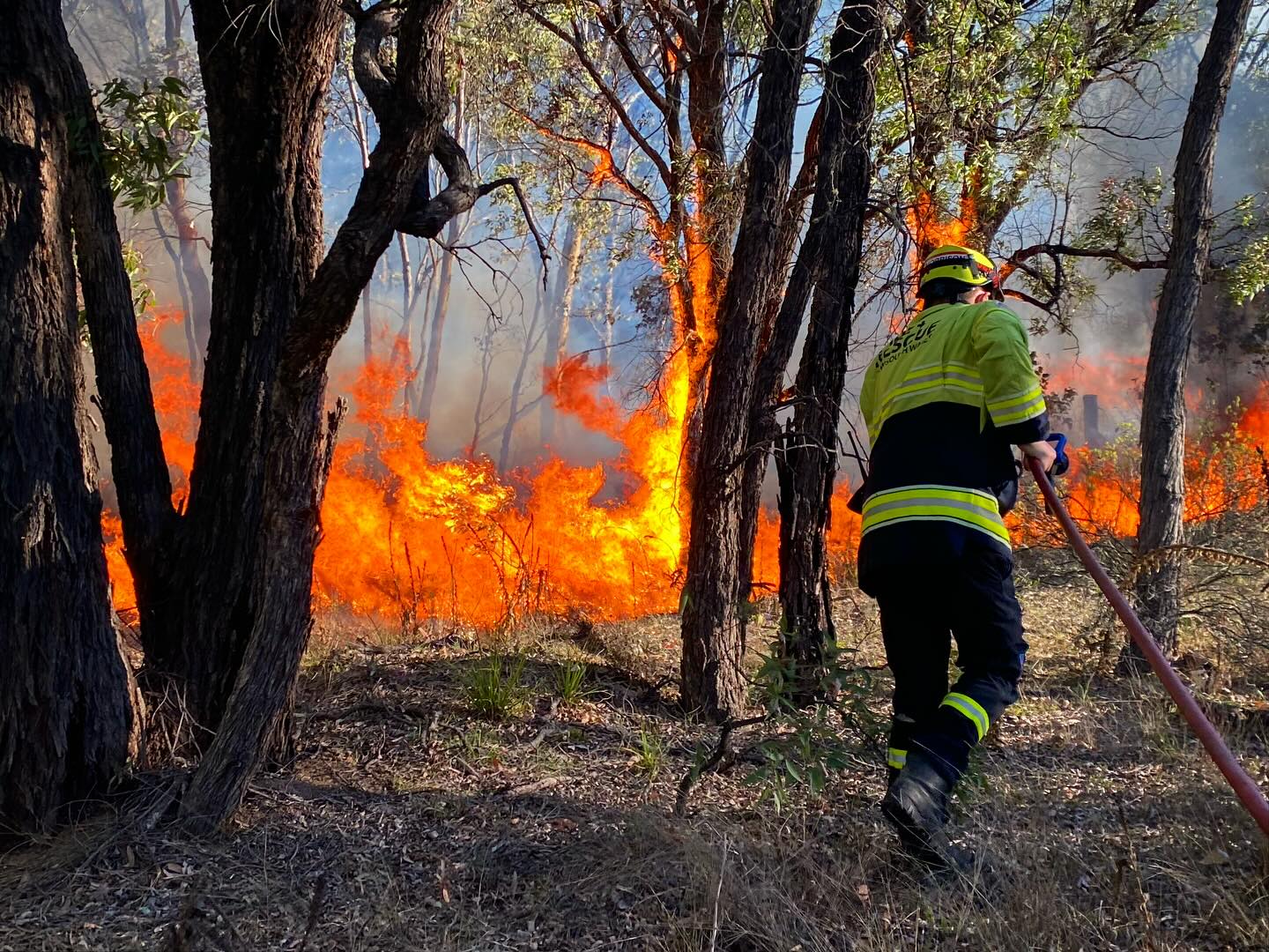 A firefighter uses a hose to battle a blaze