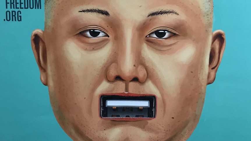A poster showing Kim Jong-un's face with a USB slot for a mouth.
