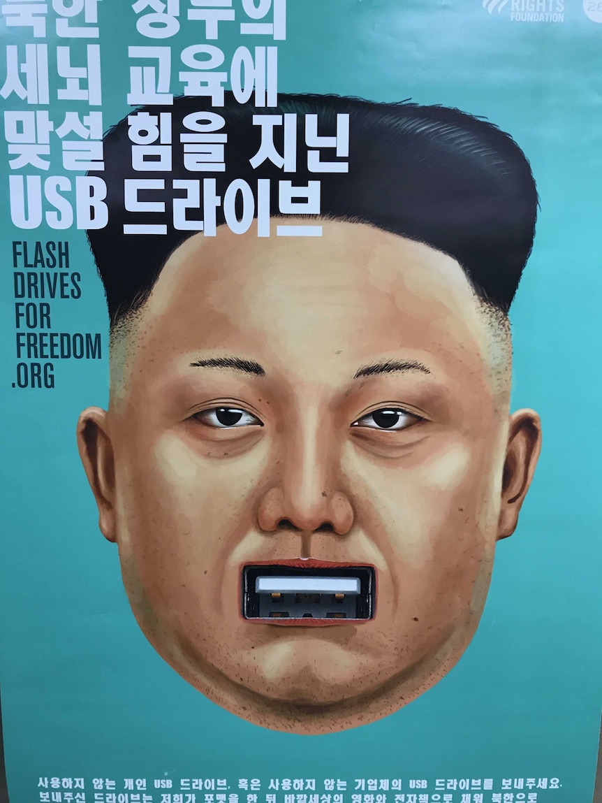 A poster showing Kim Jong-un's face with a USB slot for a mouth.