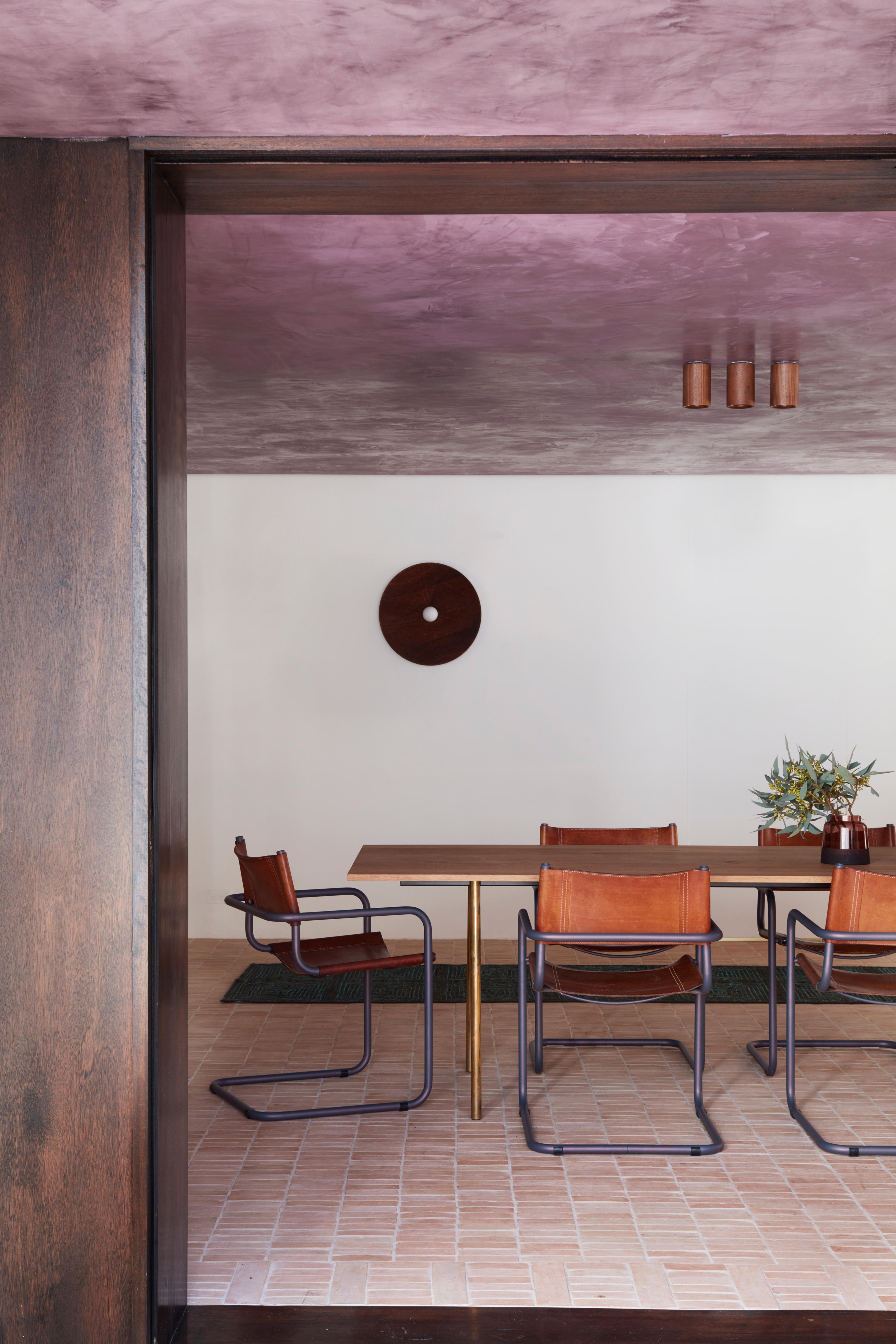 A dining room with an eggplant purple ceiling and white room walls