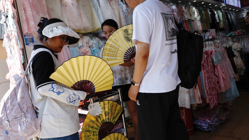 People buy yellow fans from a market in Beijing. 