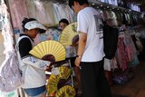 People buy yellow fans from a market in Beijing. 