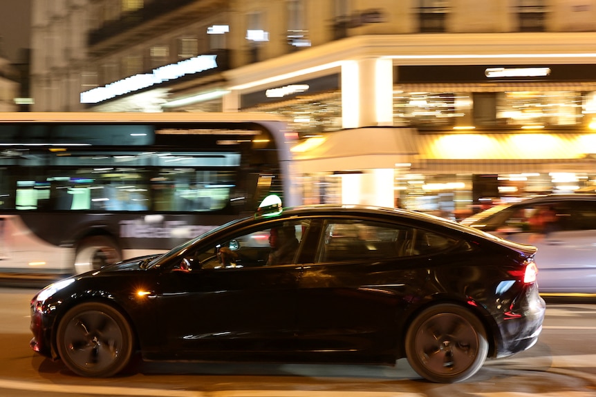 a black car drives at night
