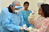Frank Bainimarama wears personal protective gown, mask and visor as he visits a coronavirus testing lab.