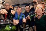 Astronauts in space holding chillies