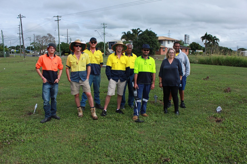 volunteers with metal detector around the unmarked graves.