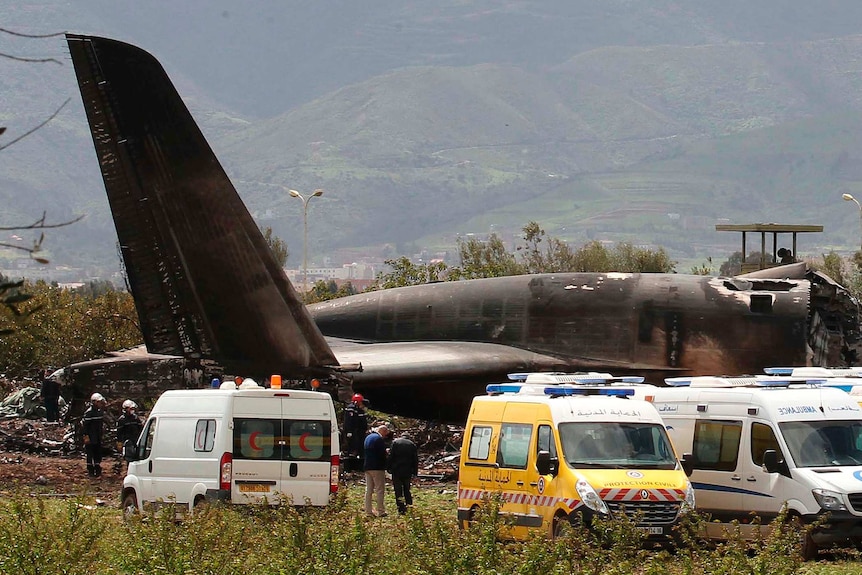 Firefighters and civil security officers work at the scene of a fatal military plane crash in Boufarik, Algeria.