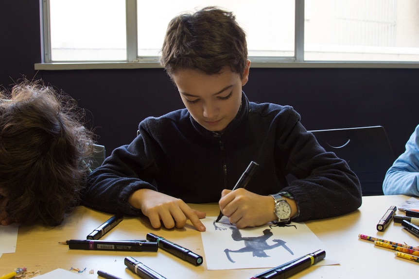 Atticus Llewellyn drawing in a comic workshop