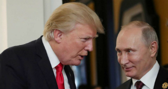 US President Donald Trump talking to a smiling Russian President Vladimir Putin.