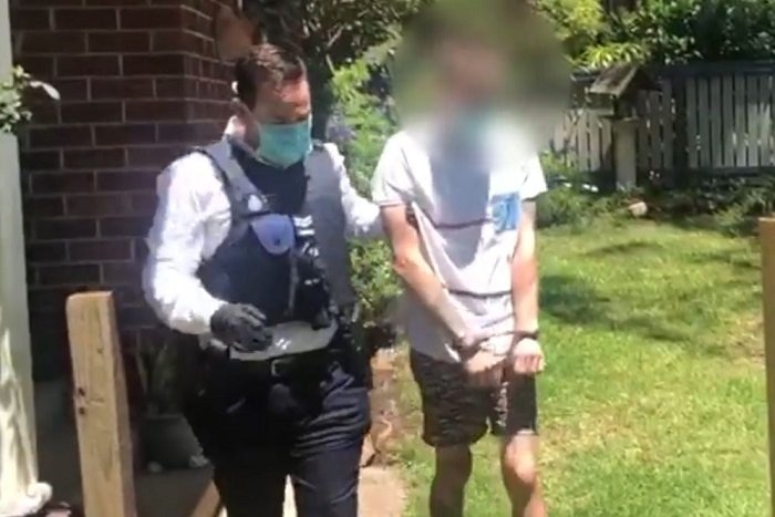 A man with his face blurred is arrested by police